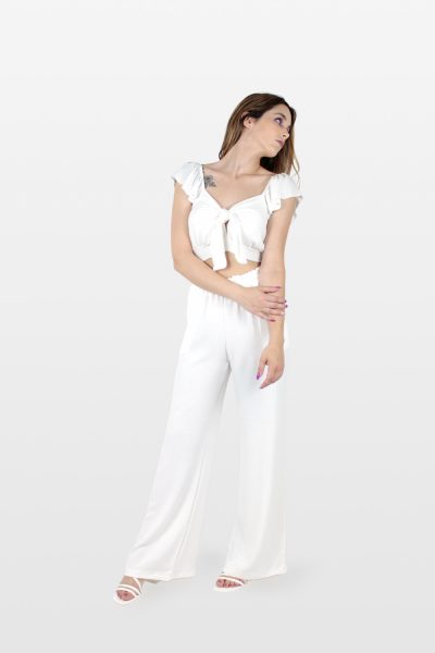 Conjunto de top com laço e calça fluida branco.