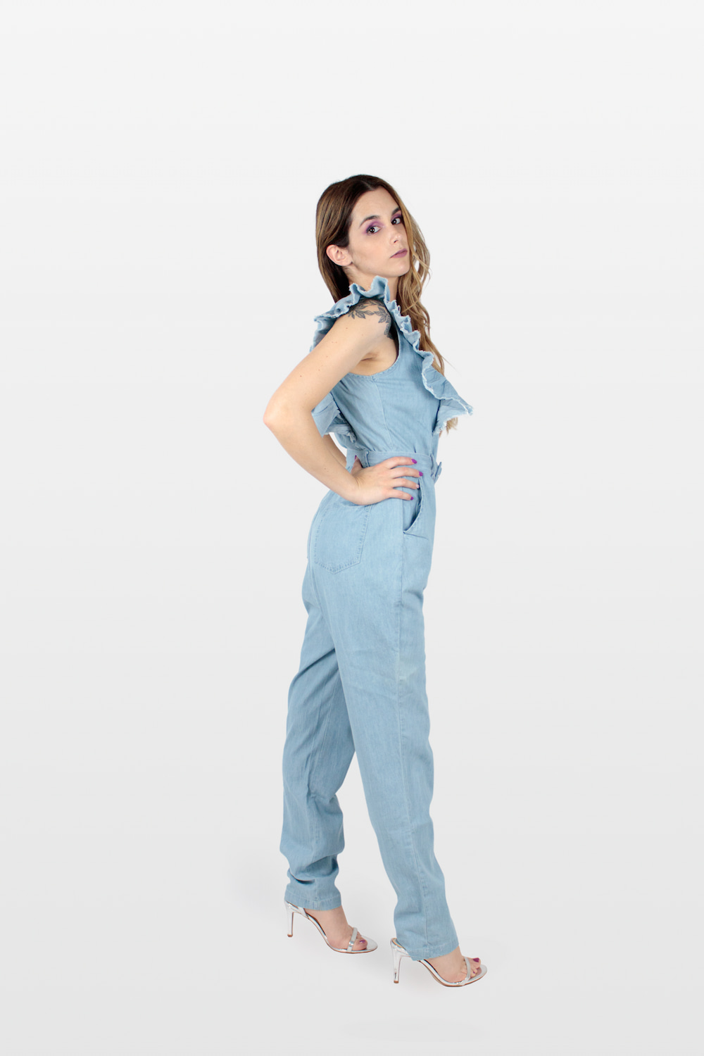 Macacão de ganga comprido com cinto e folhos azul, lado.