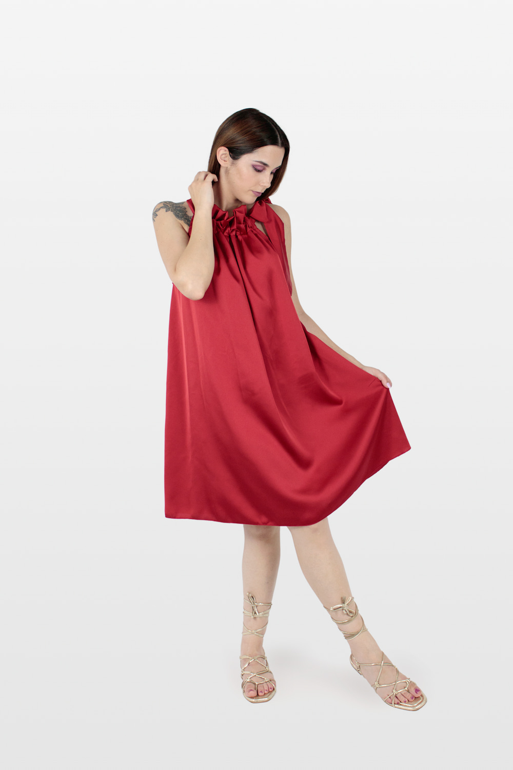 Vestido acetinado com folho no decote e laço no ombro vermelho.