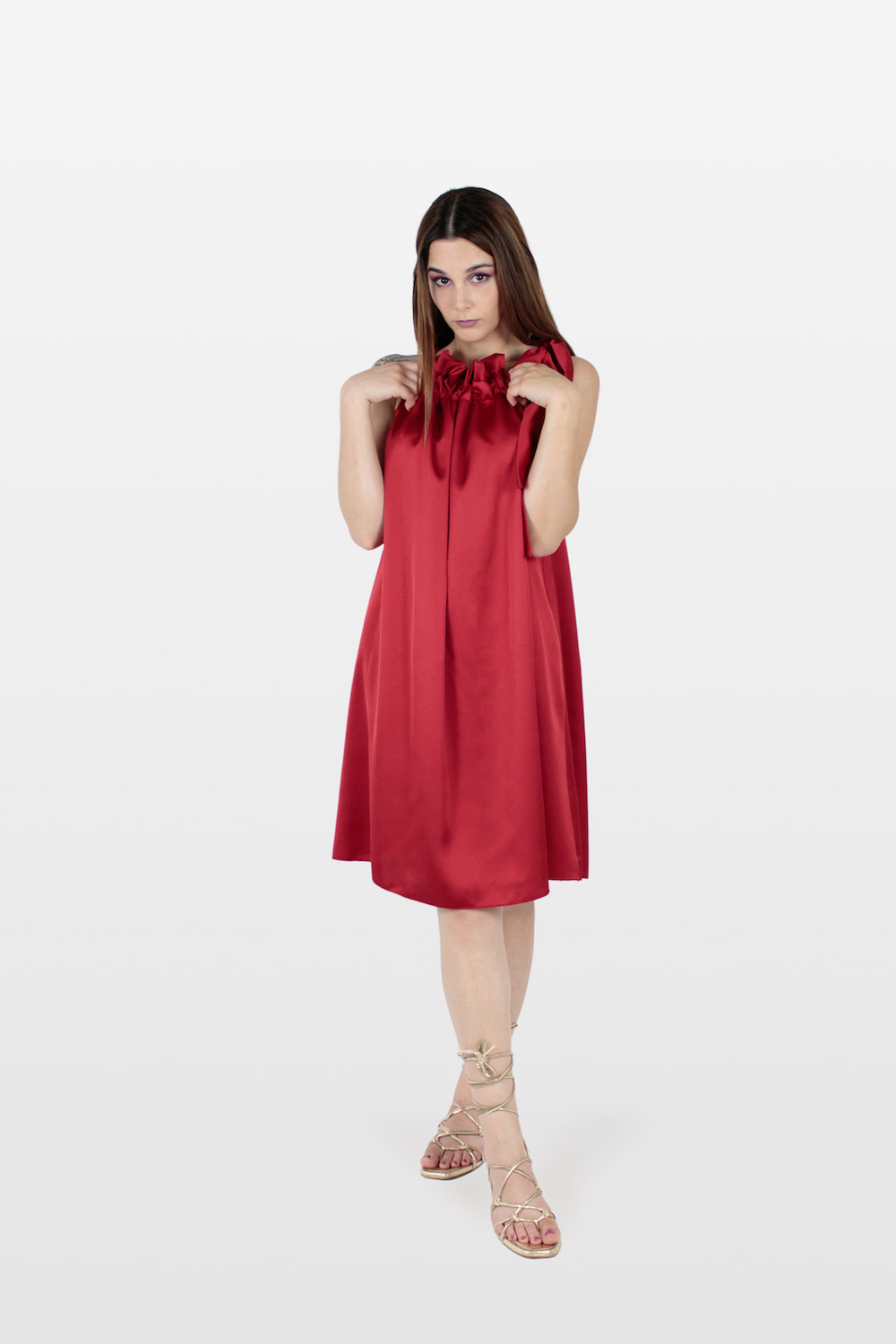 Vestido acetinado com folho no decote e laço no ombro vermelho.