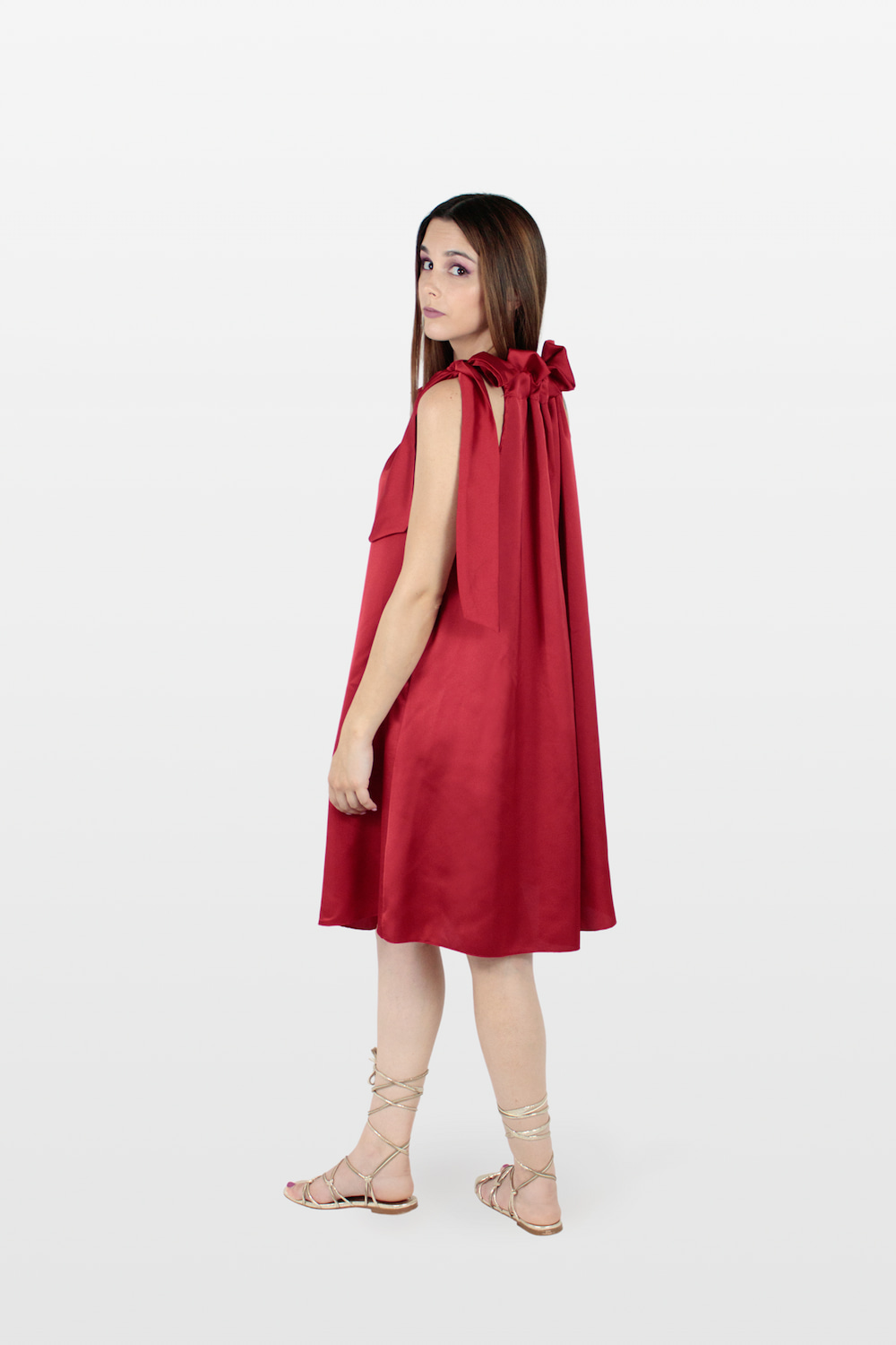 Vestido acetinado com folho no decote e laço no ombro vermelho, lado.