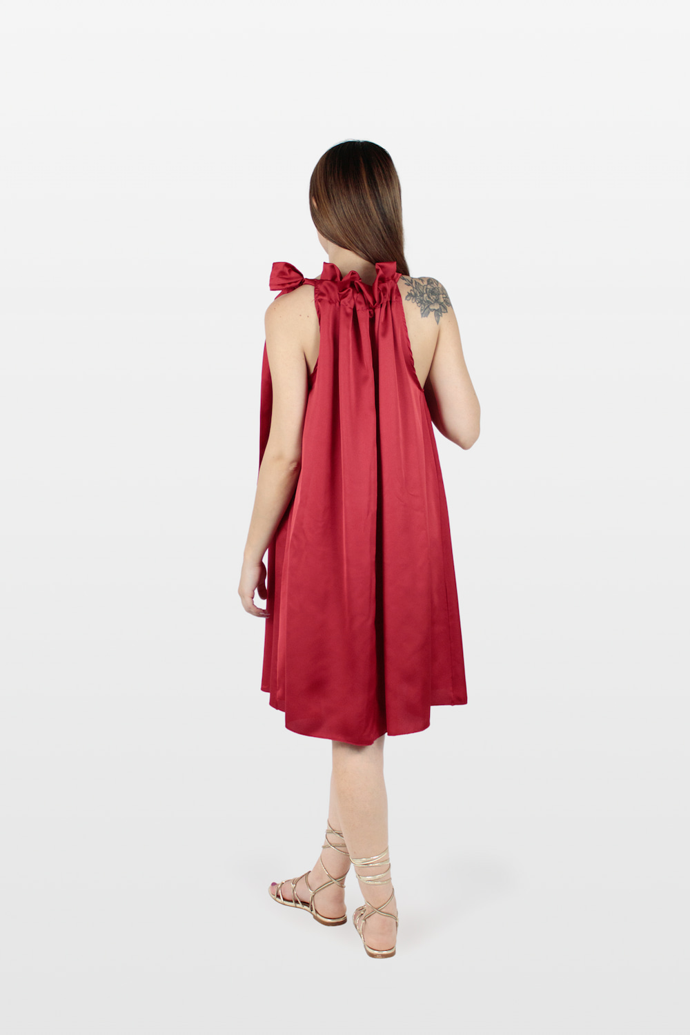 Vestido acetinado com folho no decote e laço no ombro vermelho, trás.