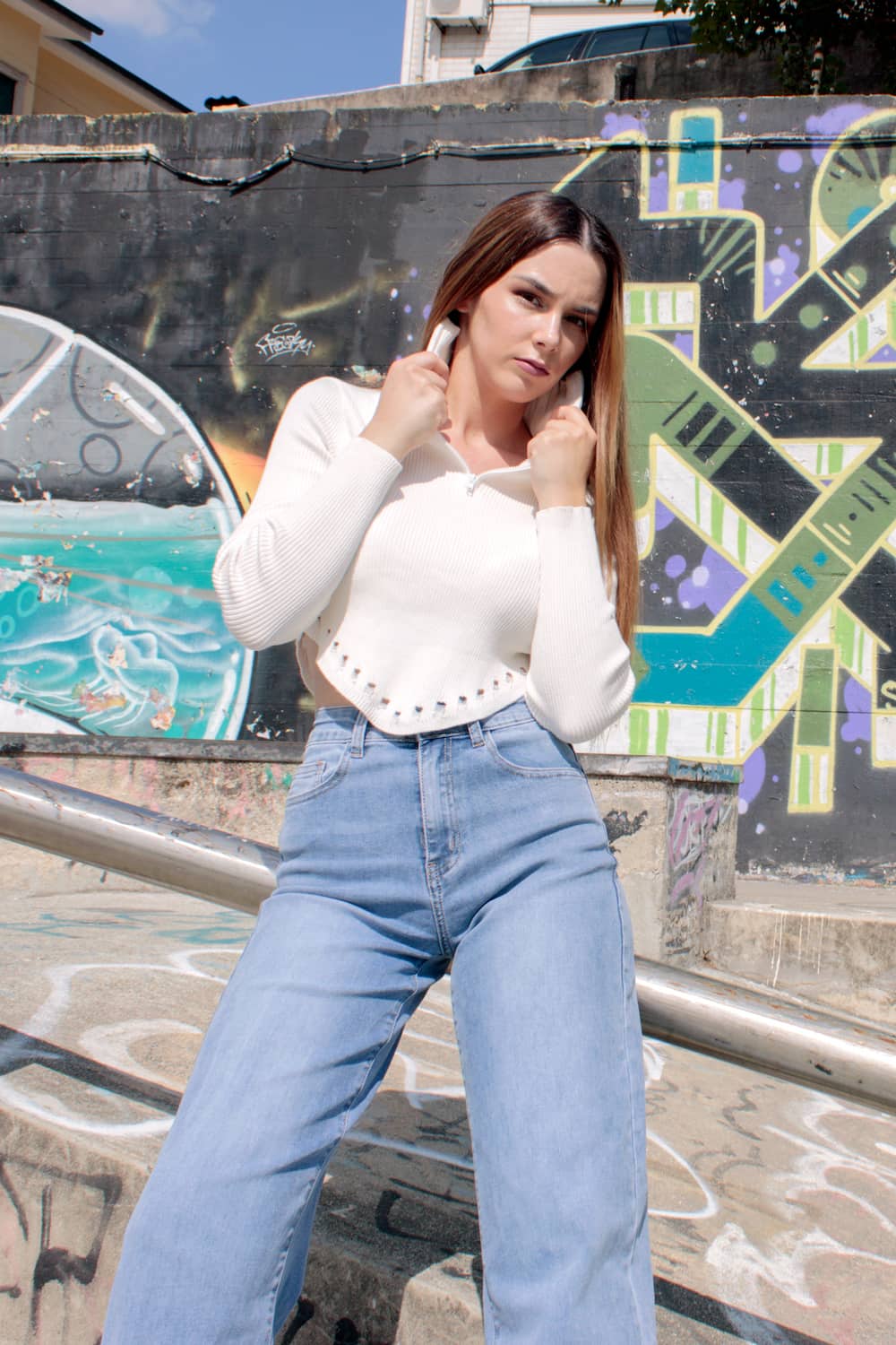 Top curto com fecho na gola e bordado no fundo branco.