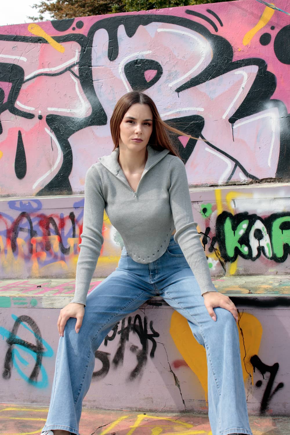 Top curto com fecho na gola e bordado no fundo cinzento.