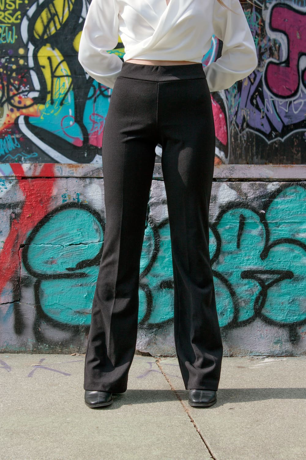 Calças lisas flare com elástico na cintura preto, frente.