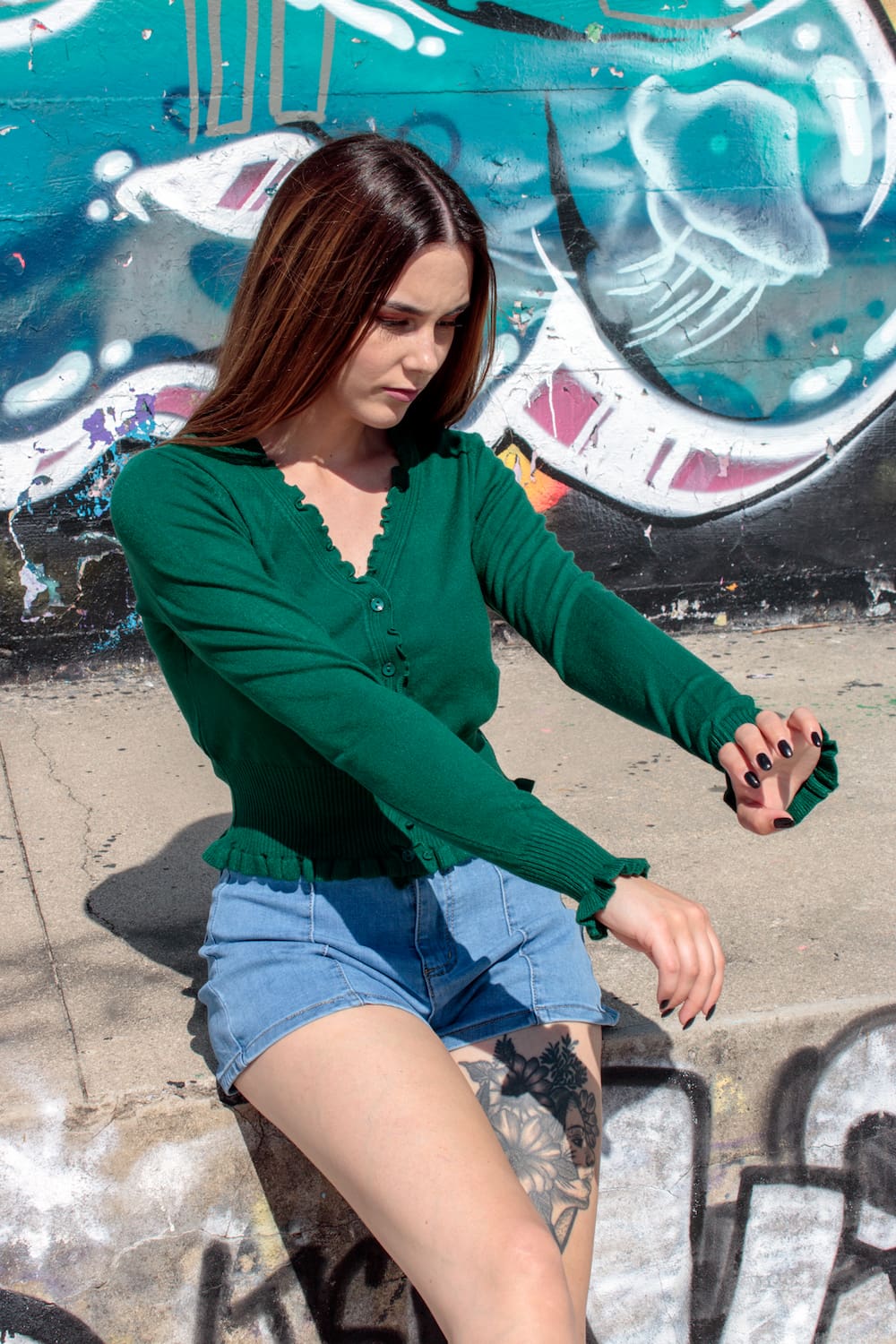 Casaco de malha com botões e folhos na gola e nos punhos verde.