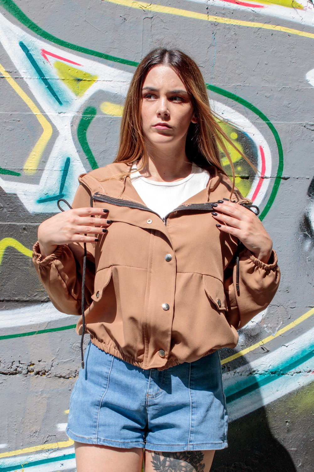 Parka curta com aperto de fecho e molas com capuz castanha, frente fechada.