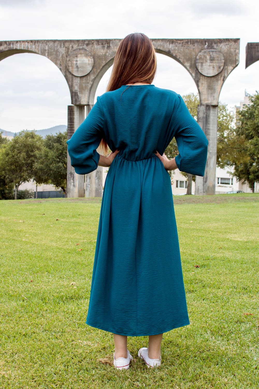 Vestido midi fluido com elástico na cintura azul, trás.